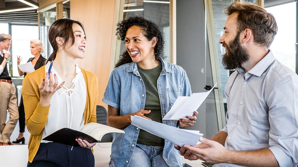 Three colleagues conversing in a work setting