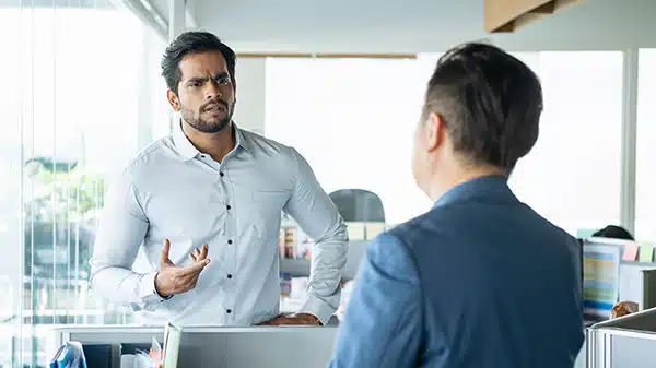 one employee appearing upset with another in an office setting