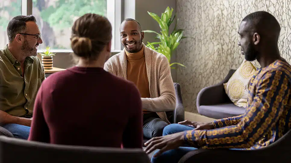 group of diverse people sitting in chairs and talking