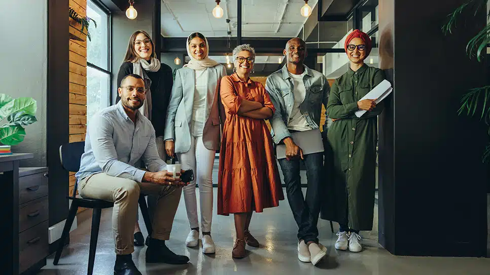 Multicultural business team smiling at the camera in an office