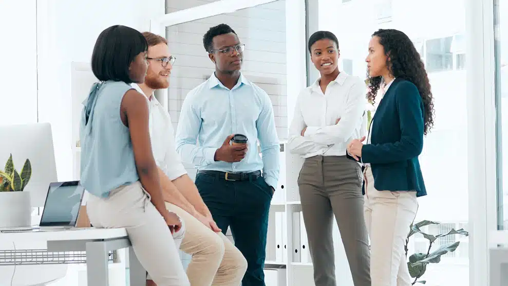 A diverse team of employees conversing in an office setting