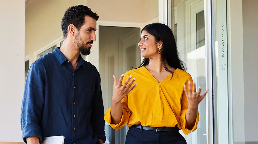 man and woman conversing outside an office