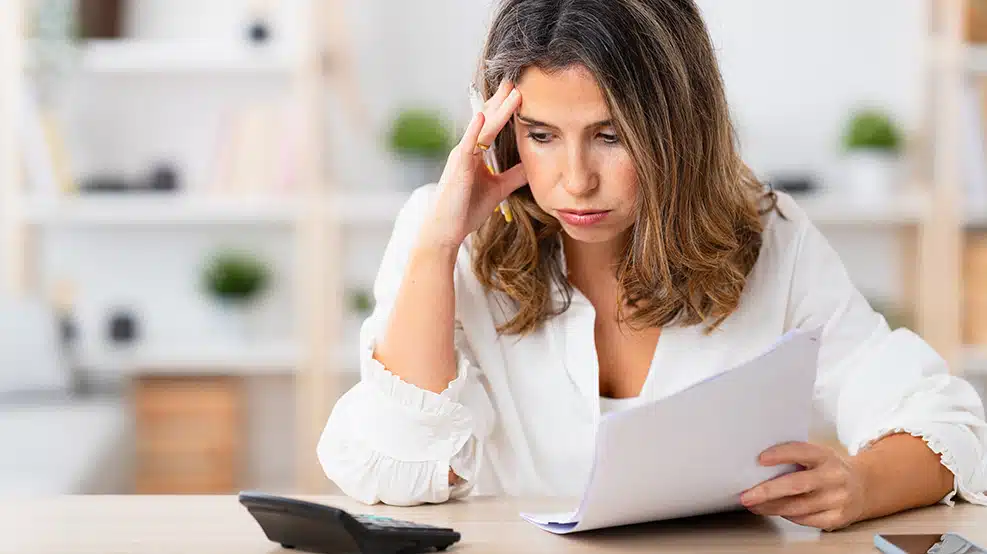woman looking at documents and calculator