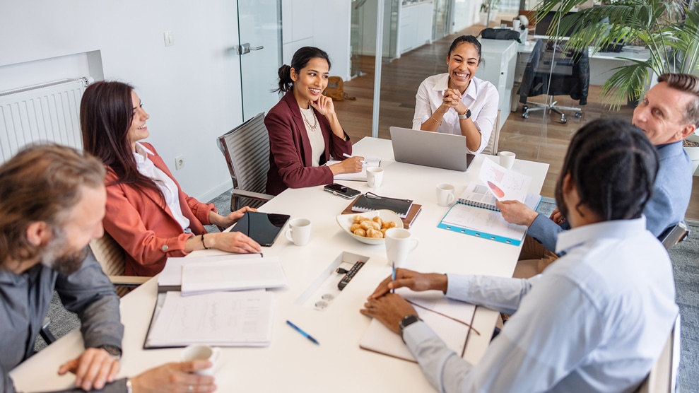 Group of smiling colleagues around a conference table