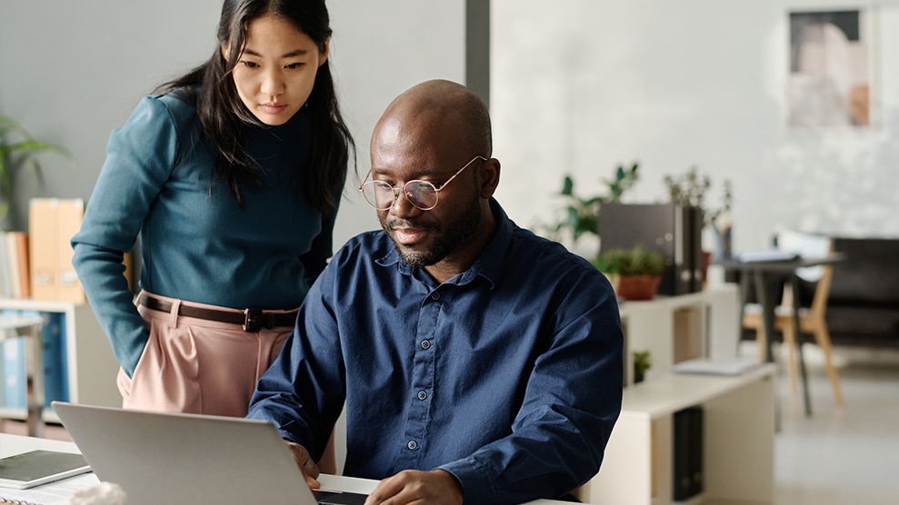 Coworkers reviewing something on laptop